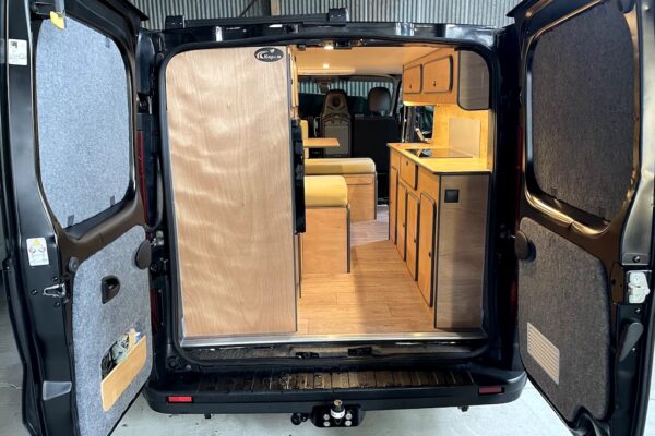Intérieur aménagé d’un van avec kitchenette en bois