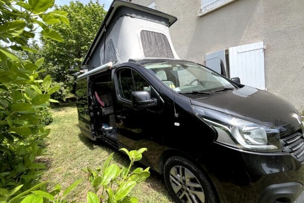 Van aménagé noir avec toit relevable ouvert
