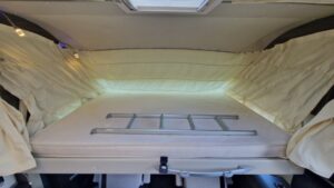 Lit escamotable dans un van aménagé