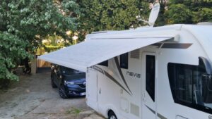 Camping-car avec store déployé dans une cour