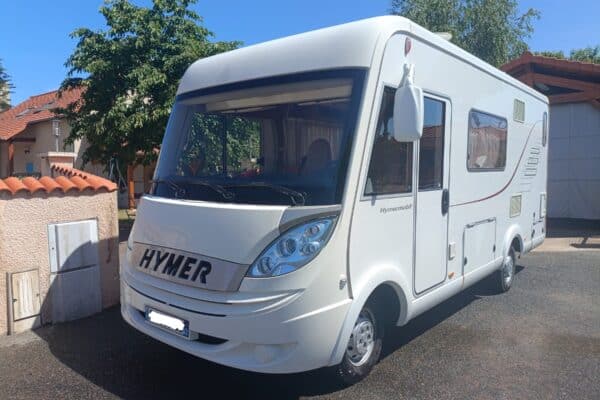 Camping-car Hymer blanc stationné en allée résidentielle