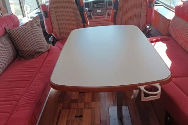 Intérieur de camping-car avec table et banquettes rouges