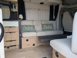 Intérieur de camping-car avec banquette et coussins verts