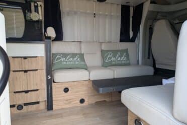 Intérieur de camping-car avec banquette et coussins verts