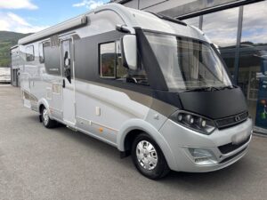 Camping-car gris et blanc stationné devant bâtiment