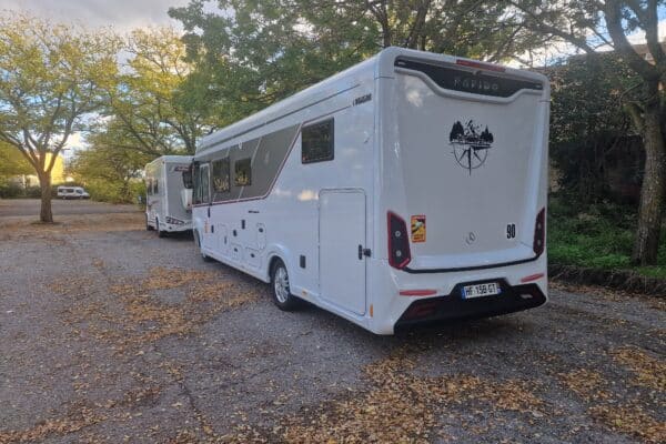 Deux camping-cars garés sous des arbres en automne
