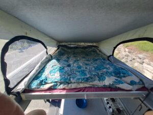 Lit aménagé dans un van avec fenêtres latérales