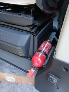 Extincteur rouge fixé sous siège de camping-car