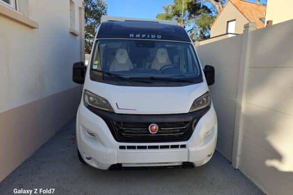 Camping-car blanc garé dans une allée étroite