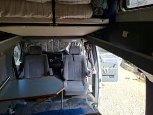Intérieur de van aménagé avec lit et table