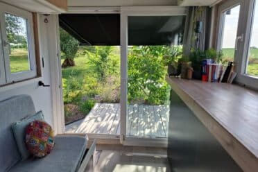 Intérieur lumineux avec porte ouverte sur jardin verdoyant