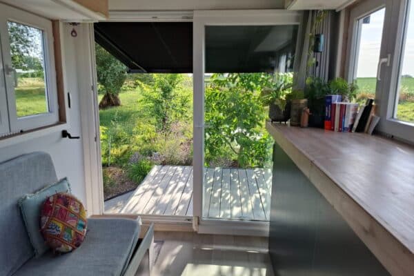 Intérieur lumineux avec porte ouverte sur jardin verdoyant