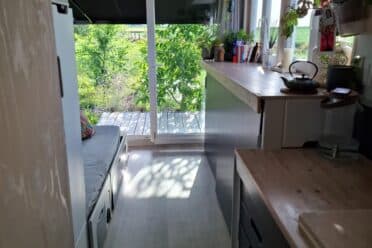 Petite cuisine lumineuse ouverte sur jardin verdoyant