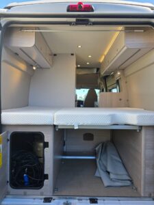 Intérieur aménagé d’un van avec lit et rangements