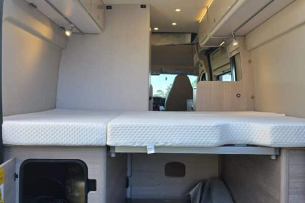 Intérieur aménagé d’un van avec lit et rangements