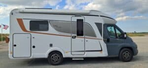 Camping-car blanc et gris stationné en bord de route