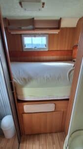 Chambre de camping-car avec lit et rangements