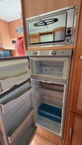 Réfrigérateur ouvert et micro-ondes dans camping-car