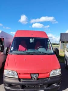 Camionnette rouge garée sous ciel bleu