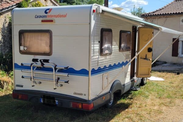 Camping-car stationné dans cour ensoleillée rurale