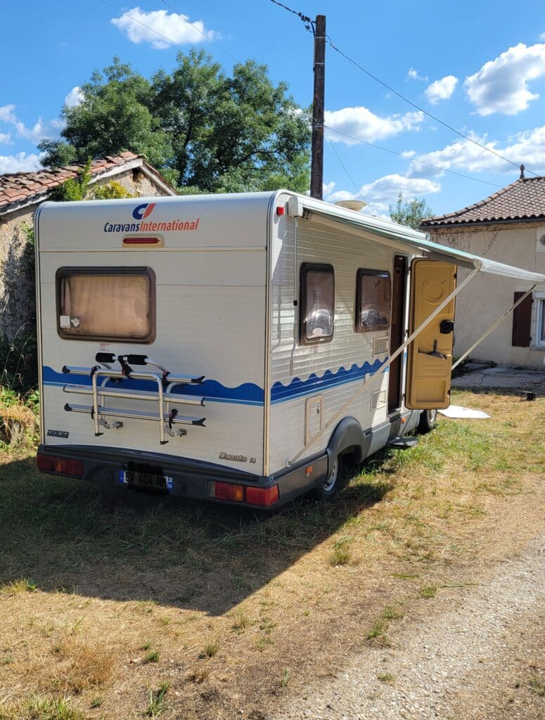Camping-car stationné dans cour ensoleillée rurale