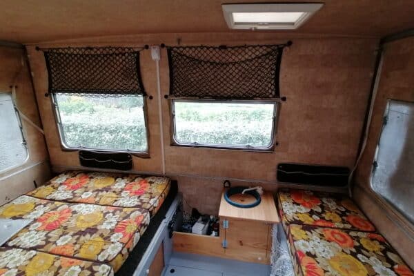 Intérieur de caravane avec banquettes fleuries