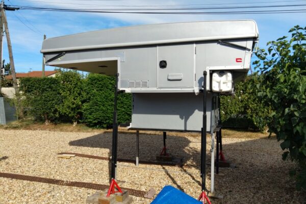 Cellule de camping sur vérins dans jardin