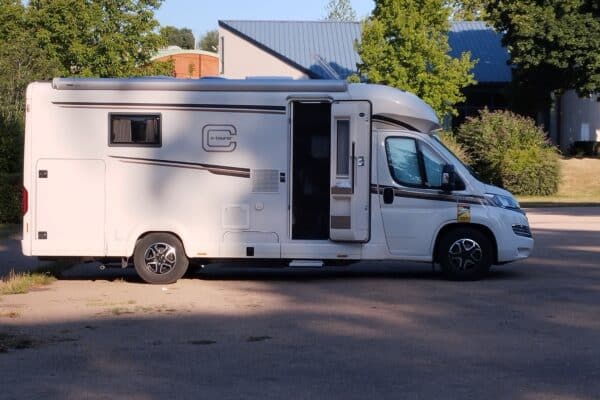 Camping-car blanc stationné porte ouverte