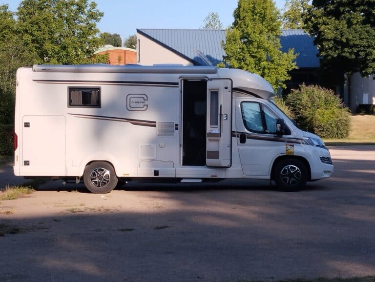 Camping-car blanc stationné porte ouverte