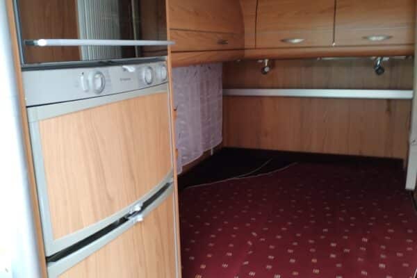 Intérieur de caravane avec lit et kitchenette