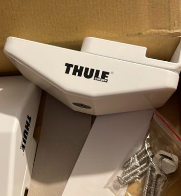 Accessoires Thule blancs dans une boîte en carton