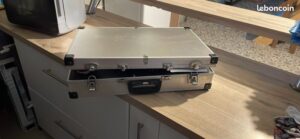 Valise métallique argentée ouverte sur un comptoir