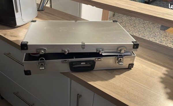 Valise métallique argentée ouverte sur un comptoir