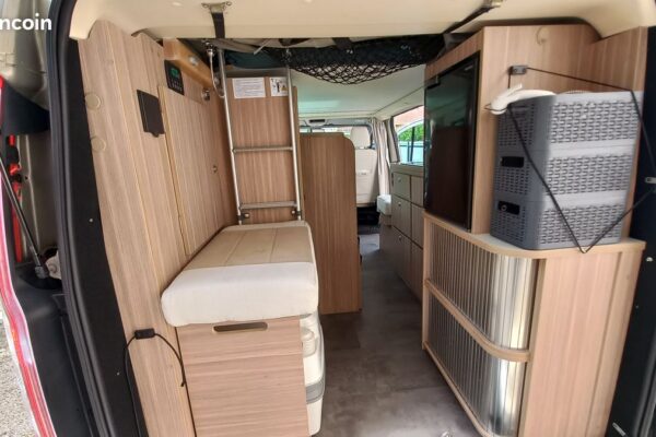 Intérieur aménagé d’un van avec rangements en bois