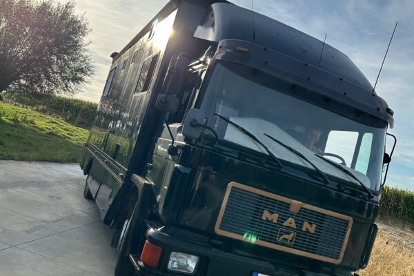 Camion aménagé noir stationné au coucher du soleil