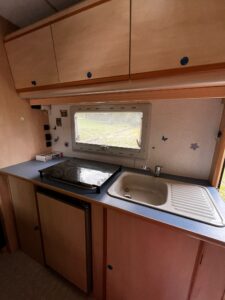 Cuisine compacte de caravane avec évier et fenêtre