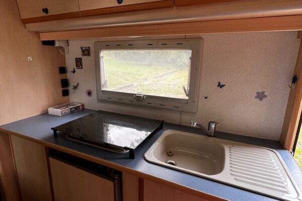 Cuisine compacte de caravane avec évier et fenêtre