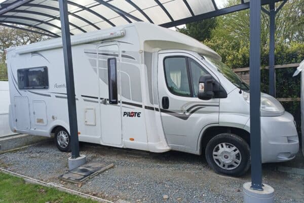 Camping-car blanc sous abri métallique