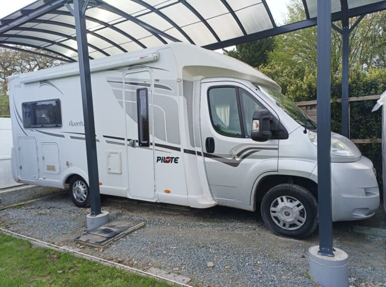 Camping-car blanc sous abri métallique