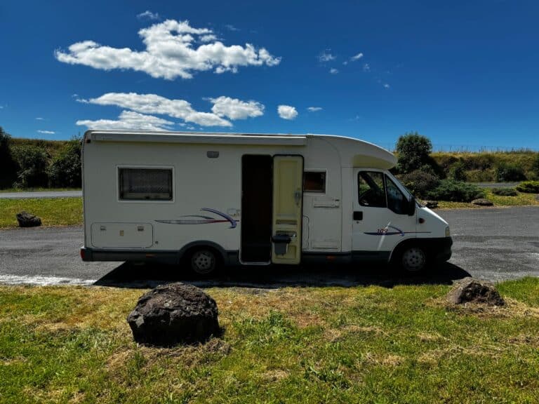 Camping-car blanc stationné sous ciel bleu