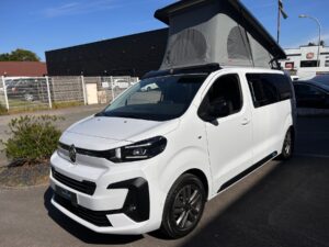 Van aménagé blanc avec toit relevable ouvert