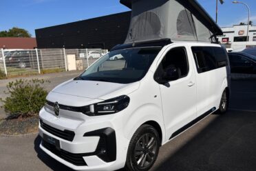 Van aménagé blanc avec toit relevable ouvert