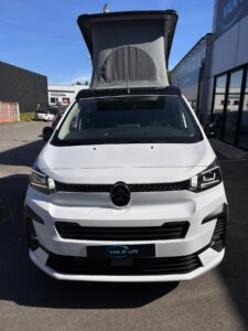 Van aménagé blanc avec toit relevable ouvert