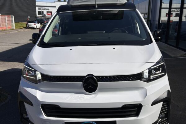 Van aménagé blanc avec toit relevable ouvert