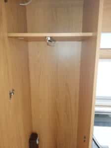 Intérieur d’armoire en bois avec porte cintres rabattable