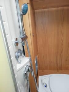 Douchette et robinet dans petite salle de bain