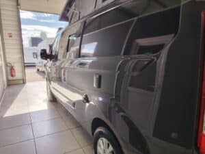 Fourgon aménagé noir dans un garage lumineux