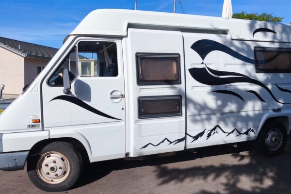 Camping-car blanc garé dans quartier résidentiel