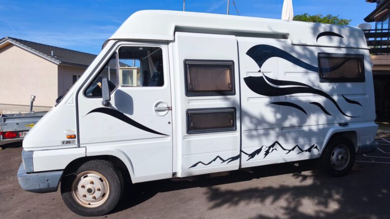 Camping-car blanc garé dans quartier résidentiel