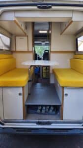 Intérieur de van aménagé avec banquettes jaunes